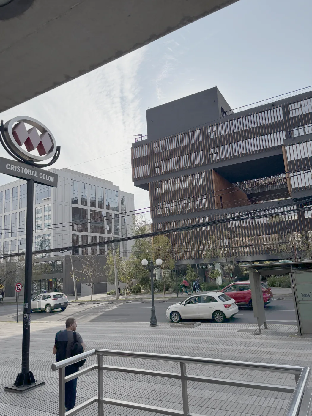 Salida del Metro Cristóbal Colón, con el tótem de la estación y el edificio de la oficina al fondo