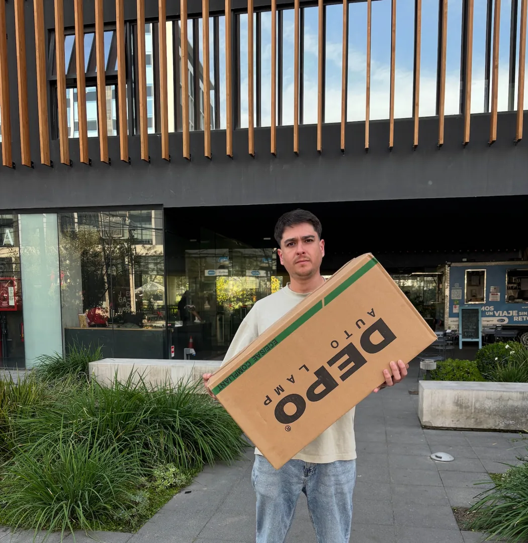 Cliente recibe en la entrada de la oficina la caja del repuesto que compró