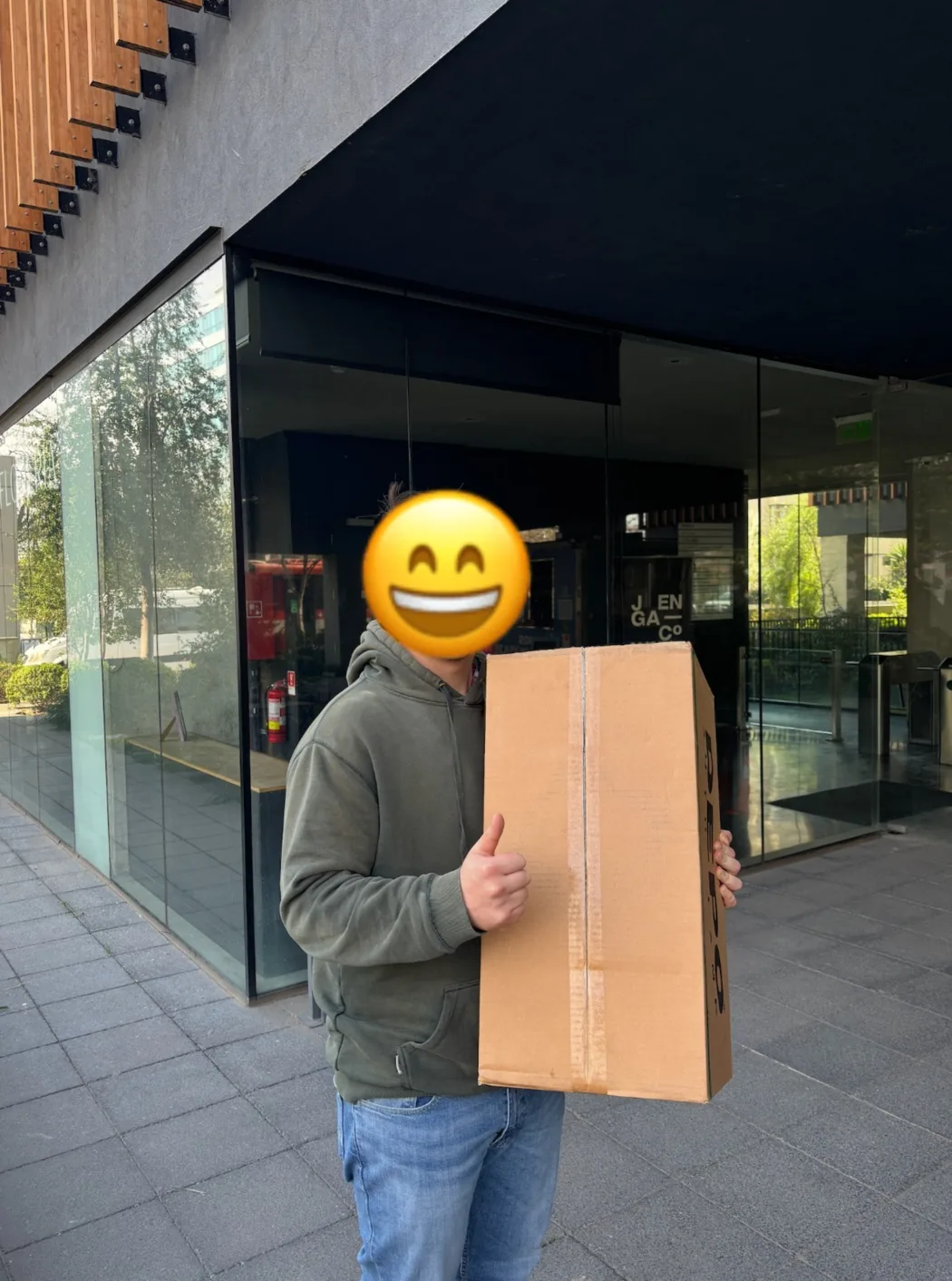Cliente retira una caja larga en la entrada de la oficina de Repartes